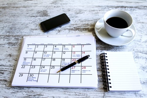 Agenda met koffie en mobiel op achtergrond-500x333